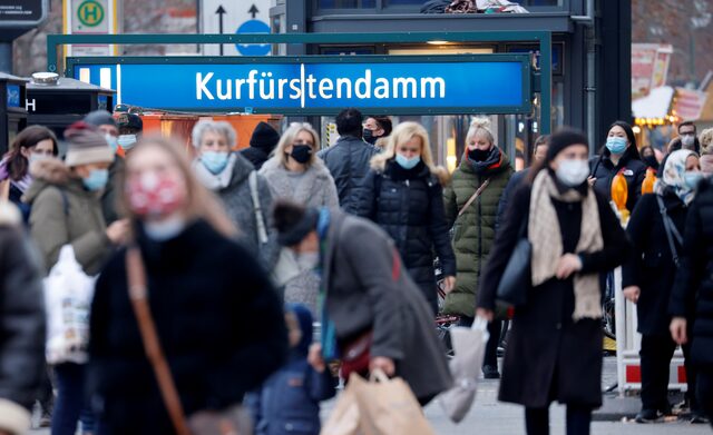 People wearing protective face masks stroll along the Kurfürstendamm, Germany shopping boulevard.
Image Source: Reuters